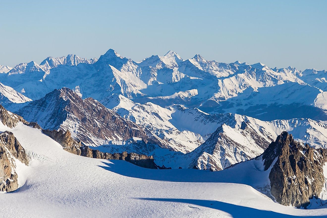 A hiker standing on an Alpine peak